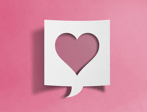 Paper speech bubble with heart cutout on pink background, love and social media concept