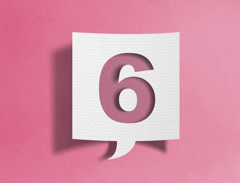 Paper speech bubble with number six cutout on pink background, ranking and sequence concept