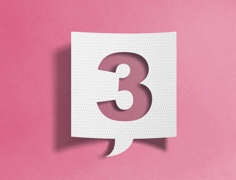 Paper speech bubble with number three cutout on pink background, ranking and sequence concept
