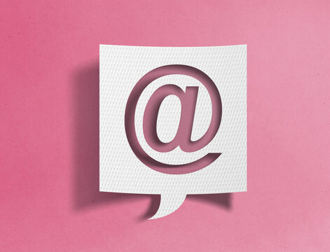 Paper speech bubble with at symbol cutout on pink background, email and communication concept