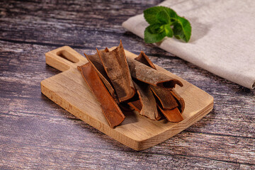 Cinnamon sticks on wooden cutting board with mint leaf © Andrei Starostin
