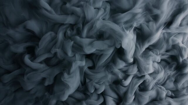 Dense gray smoke swirling inward with folding plumes, layered vortices, soft ribbons, moody contrast, and atmospheric texture for abstract commercial backgrounds