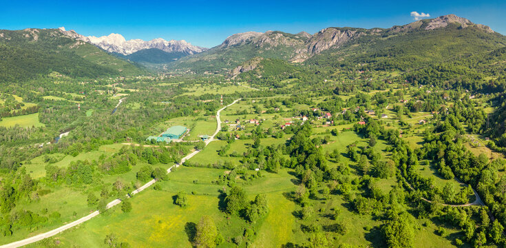 Aerial panoramic view of lush green mountain valley with scatter