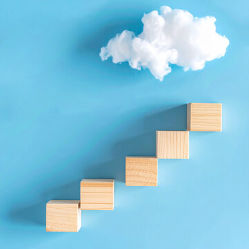 Piezas de madera formando una escalera ascendente hacia una nube sobre fondo azul. Concepto de progreso, crecimiento personal, superaci&oacute;n, &eacute;xito, objetivos y desarrollo profesional.