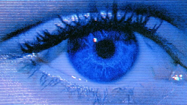 Seamless loop animation background of blue human eye blinking in extreme close up with digital screen texture
