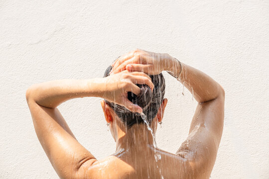 Beautiful woman's hand She was washing her hair and nourishing her scalp. Shampoo and conditioner	