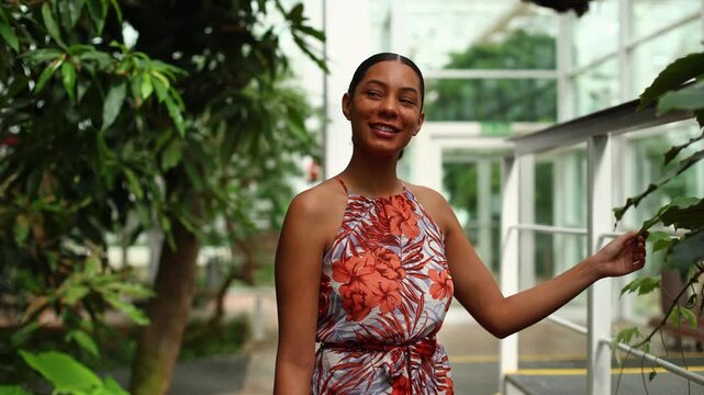 Young woman admiring nature in a tropical botanical garden greenhouse