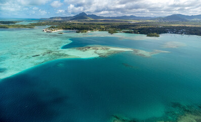 Aerial View of a Turquoise Lagoon with Coral Reef and Mountain © Johann