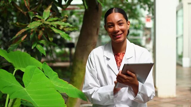 Female botanist researcher studying plants in a greenhouse