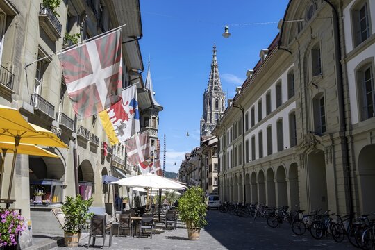 M&uuml;nstergasse with historic houses decorated with flags, tower of the Bernese Minster in the back, old town, Bern, Canton of Bern, Switzerland