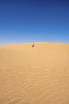 Lonely person photographing on a sand dune, sand dunes with wave patterns, sea of dunes, sandy desert, impressive desert landscape, Namib Naukluft Park, Namib Desert, Namibia
