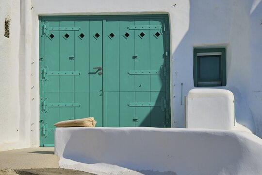 Close-up of a large green door at a white minimalist house with Mediterranean flair, Syrmata, boat garages, boathouse, boathouses, beach house, Goupa, Goypa, Goupa Kara, Kimolos, Cyclades, Greek Islands, Greece