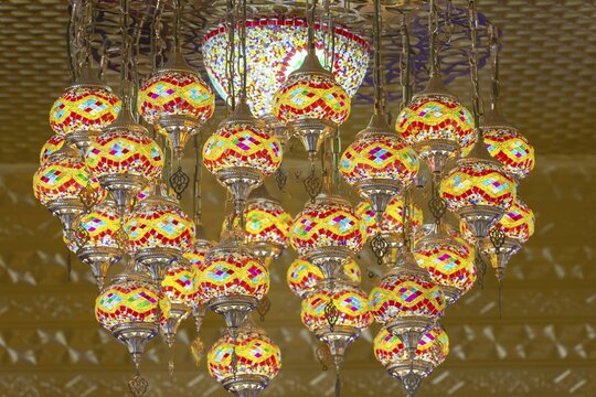 A mosaic of warm colors and fine glass light fills the interior of the main chedi. The chandelier looks like a floating mandala, whose glowing patterns deepen the silence of the sanctuary. Each lamp shines its own spark of insight, carried by the golden glow of the temple. Wat Phra That Sorn Kaew, Khao Kho Mountains, Phetchabun, Isan, Thailand