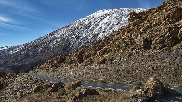 A winding road passes a snowy mountainside, Teide, Parque Nacional del Teide, Teide National Park, volcano, volcanism, UNESCO World Heritage Site, Tenerife, Canary Islands, Spain
