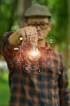 Man Holding Light Bulb with Clean Energy Icons, Illustrating Sustainable Ideas