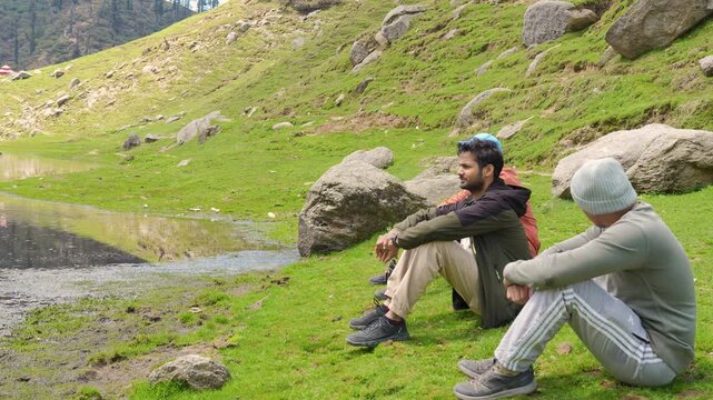 Hikers resting by Bhrigu Lake, manali, Himachal Pradesh. Mountain trekking break.