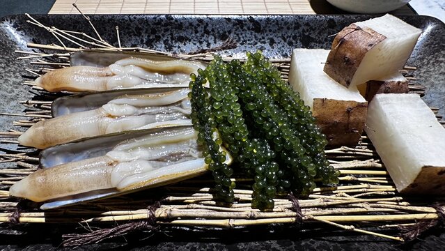 Raw Geoduck Clams, Green Sea Grapes, and White Root Vegetable on Tray