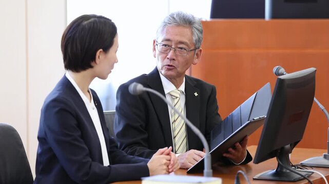 法廷で打ち合わせを行う男性検事と女性検事