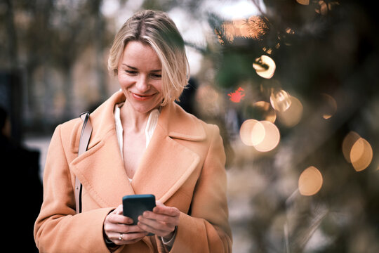 Smiling woman using mobile phone