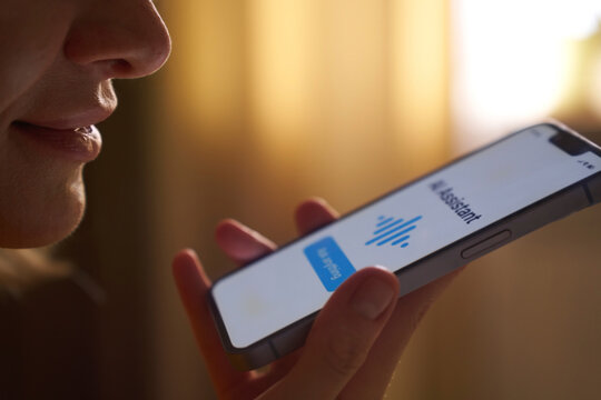 Close-up of mouth speaking into smartphone AI voice assistant