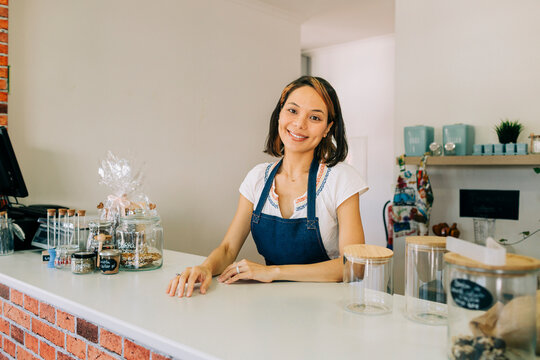 Proud entrepreneur smiling at the counter of a zero waste shop