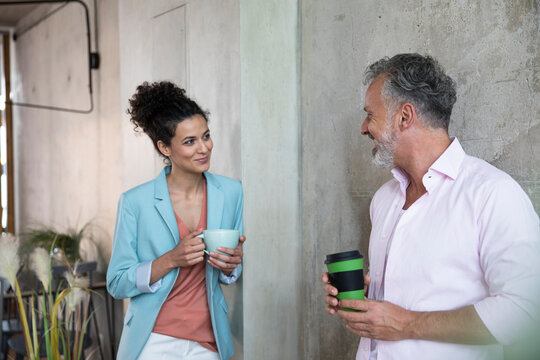 Smiling businessman and businesswoman having a coffee break in a loft
