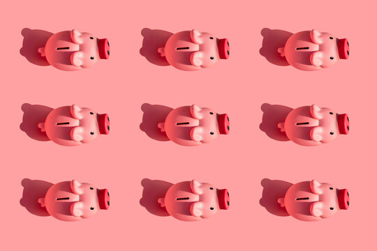 Pattern of rows of piggy banks against pastel pink background