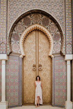 Traveler standing by ornate Moroccan door in Marrakech