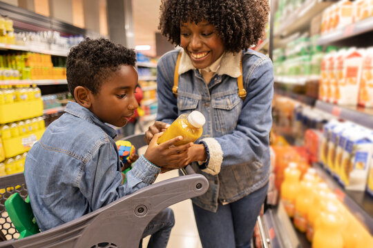 Happy mother shopping with son in supermarket
