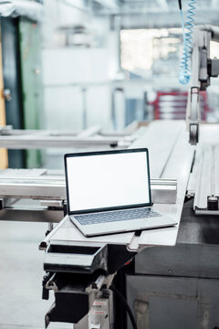 Laptop with blank screen on manufacturing equipment in industry
