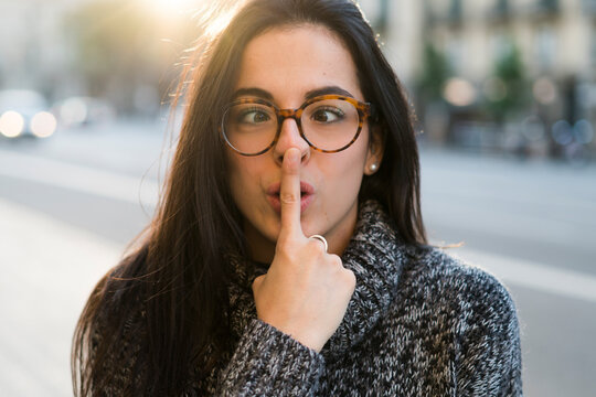 Portrait of young woman with glasses pulling faces
