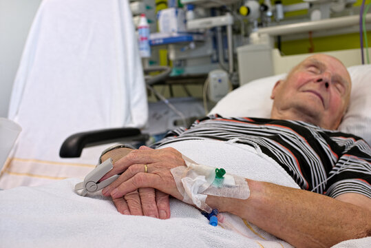 Senior man with cannulae and band-aid being in intensive care after heart attack