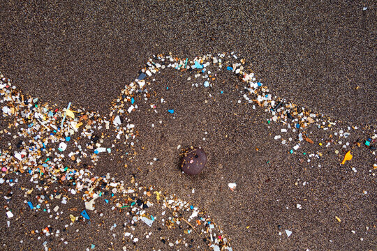 Spain, Canary Islands, Lanzarote, Playa Famara, microplastics, washed up on dark lava sand
