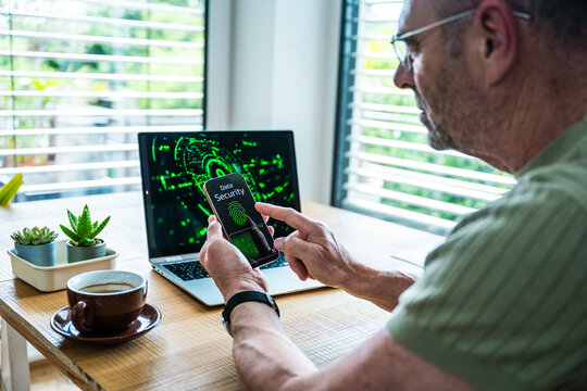Man checking data security on smartphone at office desk