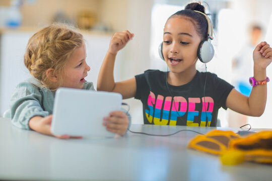 Two girls sharing mini tablet in kindergarten