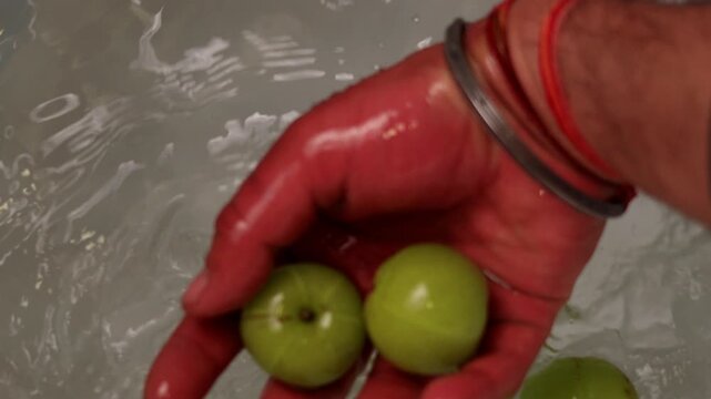 Fresh Amla fruit ( Indian gooseberry ) spinning in water bucket view from directly above