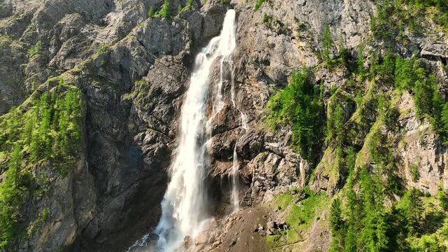 This waterfalls descend over steep limestone cliffs, where alpine meadows and mountain streams shape a dramatic natural setting. Engstligen Falls, Adelboden, Switzerland.