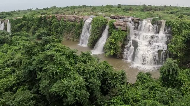 This waterfall cascades over rugged rock formations, where seasonal river flow creates a scenic landscape amid dense woodland. Ethipothala Falls, Palnadu District, Andhra Pradesh, India.