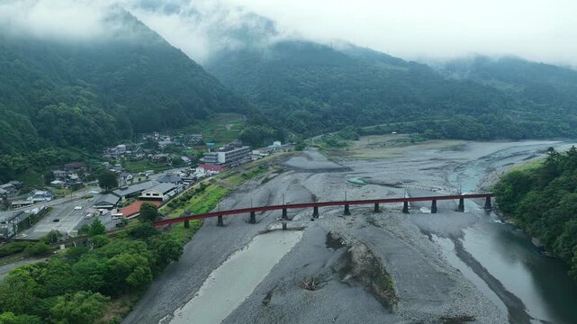 Aerial drone footage of red railway bridge over Oi River in Shimada, Shizuoka, Japan
