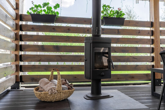 Black Wood Stove and Wicker Basket on Covered Terrace