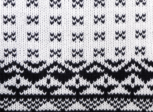 Cotton sweater texture with decorative ornament of white and dark blue color. Natural material with knitted ornament. Horizontal or vertical Christmas background with knitted fabric texture