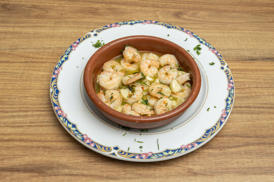 Spanish Garlic Shrimp Gambas al Ajillo Served in Terracotta Dish on Decorative Plate
