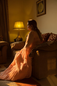 A well dressed woman sitting comfortably at her home. 