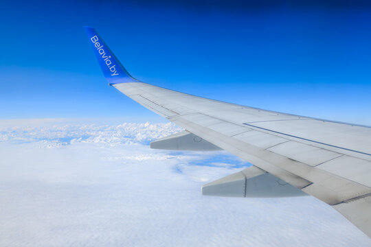 Above Caucasus Mountains &mdash; April 29, 2026: Belavia airplane wing flying over snow peaks