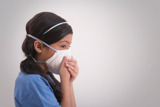 Young girl wearing pollution mask and covering her nose.(Children) 