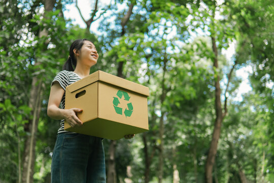 Sustainable environment concept. Recycle plastic free of zero waste, from waste to environment, woman holding recycling box on green nature forest background.