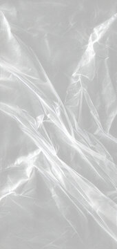 Heavily crumpled transparent plastic wrap texture with intense glossy reflections and sharp creases realistic white cellophane surface for abstract design overlay transparent png template rough edges