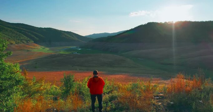 Engineer Observing Parched Dam Valley at Sunset Amidst Water Scarcity