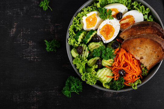 Fresh Vegetable Salad with Soft Boiled Eggs and Rustic Bread. Top view, flat lay