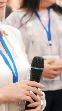 Female speaker at business conference speaks into the microphone